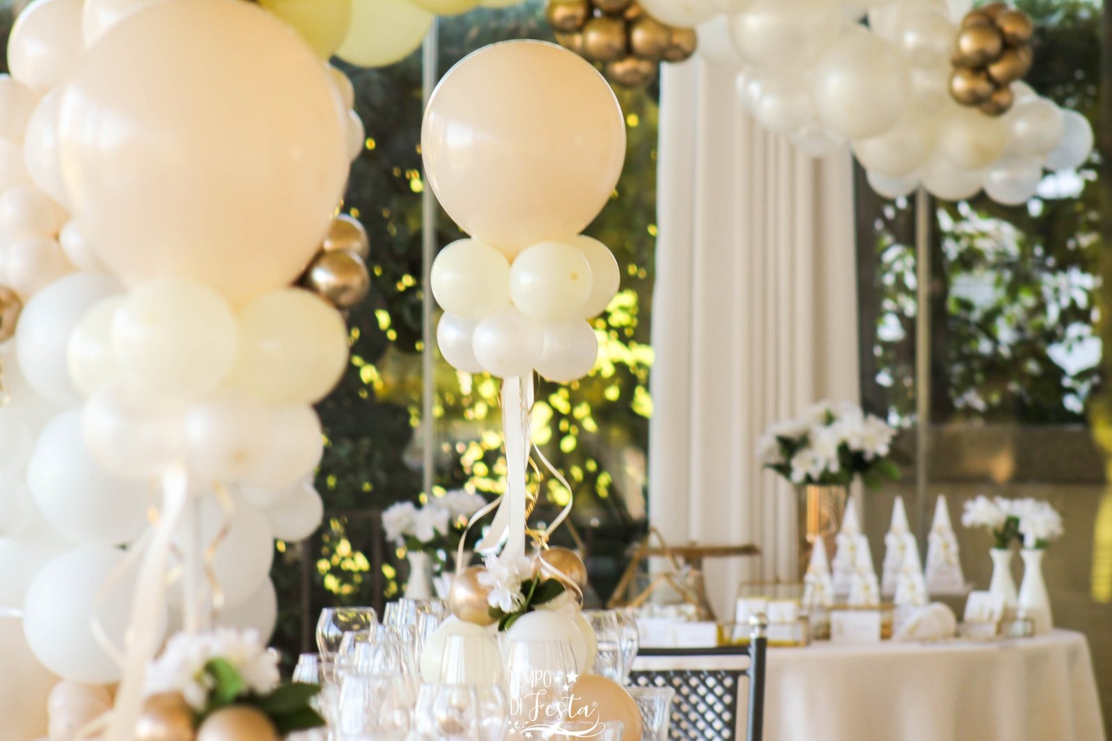 Composición de mesa con globos blancos y dorados